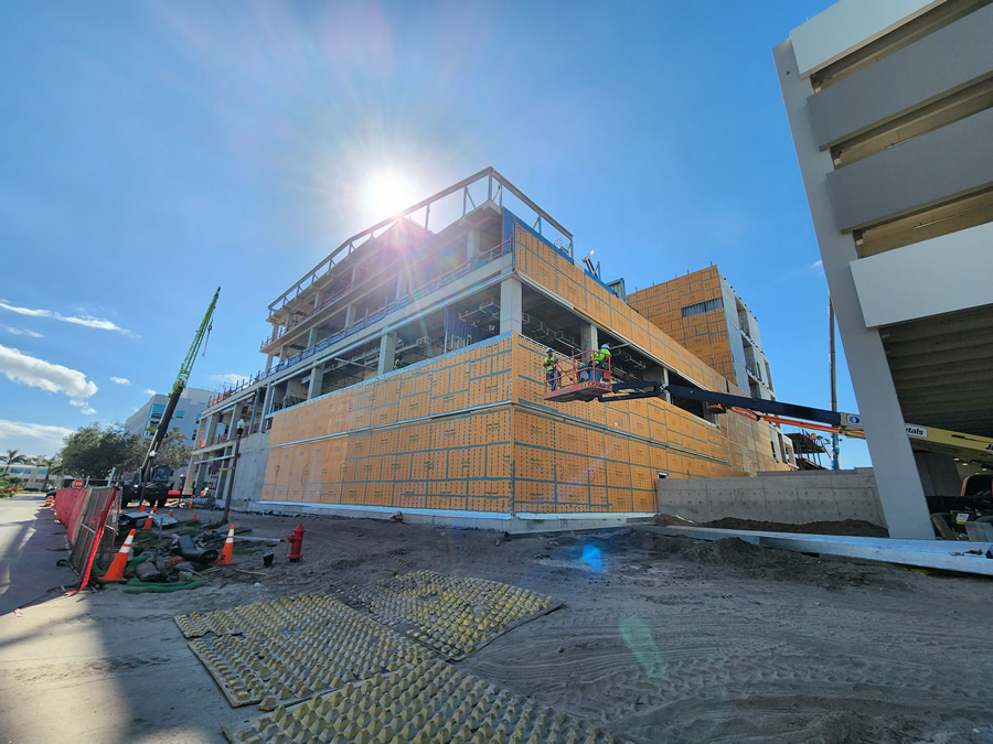 Image 9: Curtainwall panel erection continues around the building. The space constraints of the tight urban site are evident in the crane and lift staging. Courtesy of ICS